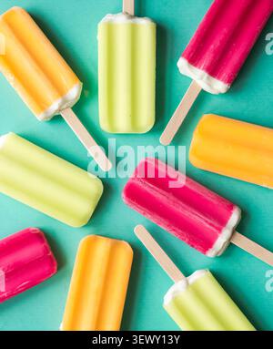 Colorful frozen ice pops on a teal background Stock Photo