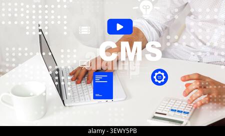 Working on a content management system with a laptop and accessories at a desk Stock Photo
