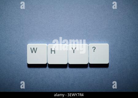 Why question text written witk white keys of a keyboard on a gray table Stock Photo