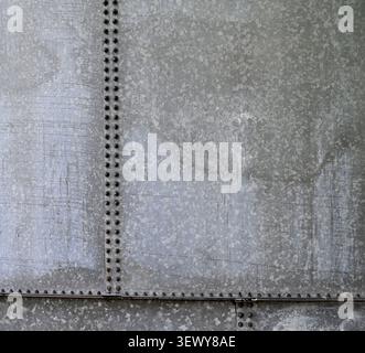 Horizontal close up of a weathered galvanized metal water tank surface with two vertical seams, one horizontal seam, water spots, white deposits Stock Photo