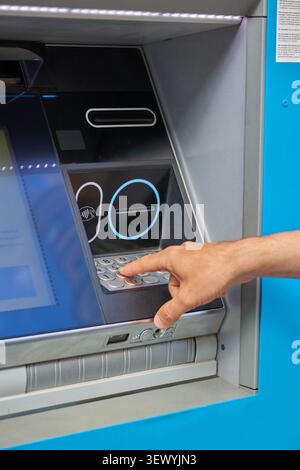 Human hand enters the PIN code on the ATM keyboard Stock Photo
