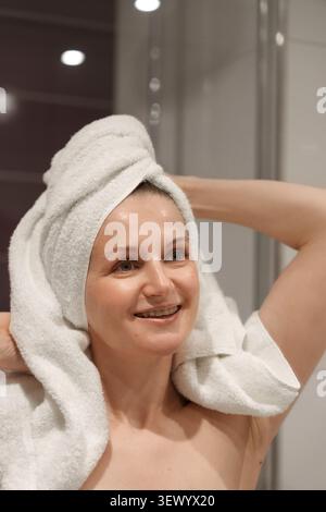 Smiling woman with towel on head after shower Stock Photo