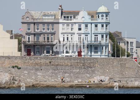 Victorian terrace houses on Grand Parade with a corner turret dome and stone sea wall, Isabella's Beach, Plymouth, June 2026 Stock Photo