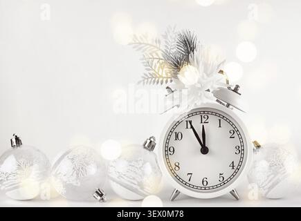 Christmas monochrome composition with festive decorations and alarm clock on white background with holiday bokeh Stock Photo