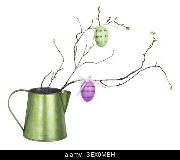 Spring twig with small buds of leaves and Easter eggs in a green metal jag isolated on white Stock Photo