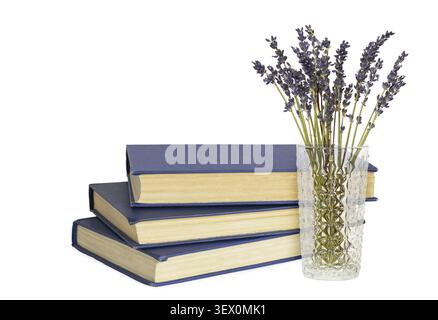 Stack of old books with blue cover and bouquet of lavender in a glass vase isolated on white background Stock Photo