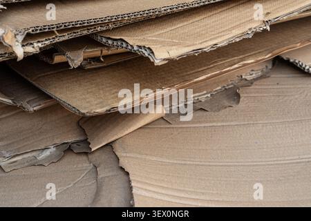 Close-up of torn and crushed corrugated cardboard sheets stacked on top of each other. Stock Photo