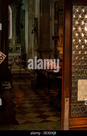 Candles burning inside a historic church in Venice, Italy Stock Photo