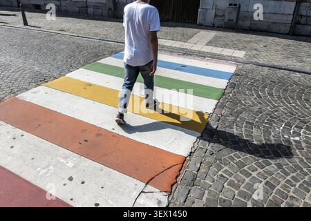 Man crossing colored pedestrian crossing in sunlight, Liege, Liege Province, Belgium Stock Photo