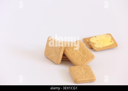 Stack of Cream Biscuits and Butter Sandwich Cookies on White Background for Snack Time Stock Photo