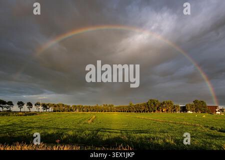 full-arc rainbow stretching across a dramatic sky Stock Photo