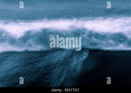 Large crashing wave washing on to beach in blurred coastal background horizontal texture created from intentional camera movement. Stock Photo