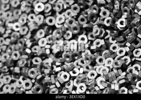 close-up shows precision metal nuts and bolts as a solid background. tech industrial technology background Stock Photo