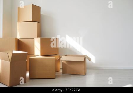 Cardboard boxes arranged on floor for moving or storage in empty room, packing or unpacking Stock Photo