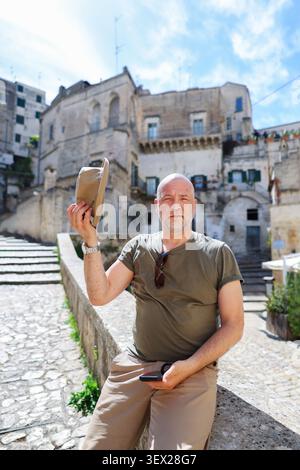 Portrait of a confident tourist exploring the UNESCO city of Matera, discovering cultural heritage and traditional Italian landmarks Stock Photo