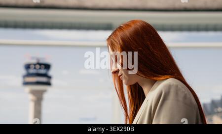 Female traveler in airport terminal taking photos with smartphone to boarding pass. Woman takes picture of flight details before departure, using phone camera to do travel document backup Stock Photo