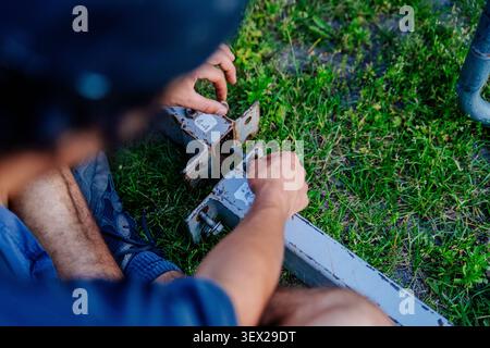 Worker hands fixing bolts and nuts on steel stage parts outdoors Stock Photo