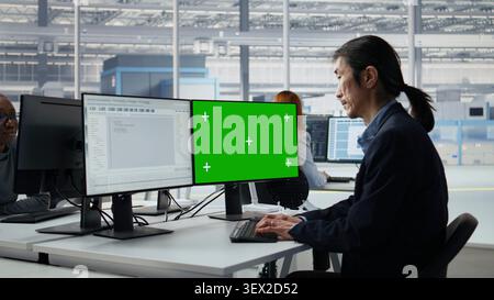 Mockup PC, reviewing microchip production and Asian man in factory workspace. Improving semiconductor hardware, green screen computer and senior manager in RD office, camera A Stock Photo