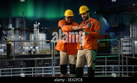 Managing resources, global oil crisis and offshore platform engineering team using laptop. Reviewing petroleum extraction metrics, maritime blockade affecting operations and coworkers, camera A Stock Photo