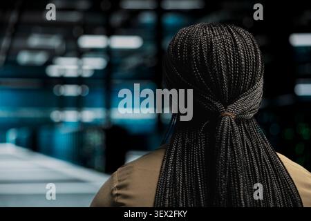 IT specialist uses a digital device in a data center to run hardware diagnostics and maintain operational stability. Stock Photo