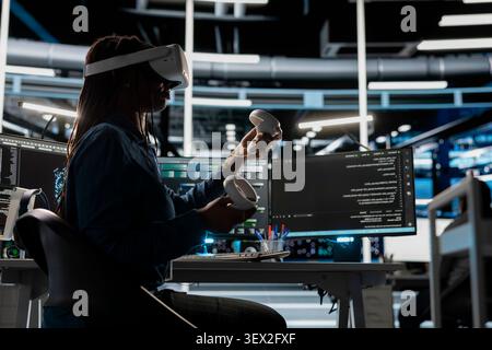 IT expert uses a VR headset in a data center to manage AI systems, train neural networks, and configure hardware. Stock Photo