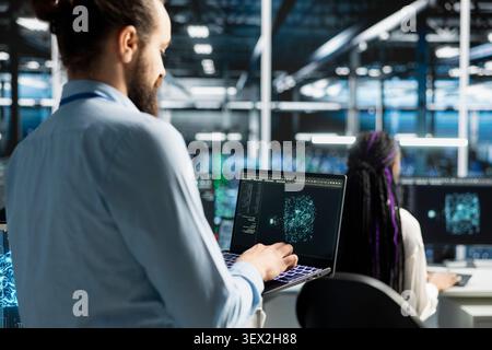 Software developer uses an AI language model assistant in a server hub to handle infrastructure maintenance. Stock Photo