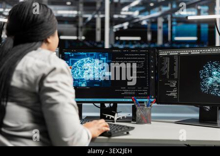Woman system administrator inspects a neural network data center, maintaining server farm systems for artificial intelligence workloads. Stock Photo