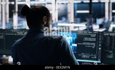 Computer scientist works on a computer to monitor AI systems, neural networks and server infrastructure. Stock Photo