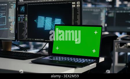 Software developer uses a green screen laptop to manage AI systems, machine learning workflows and server performance. Stock Photo