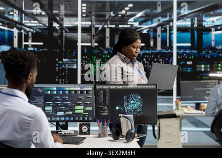 Data center manager reviews artificial intelligence systems and machine learning processes inside a data center. Stock Photo