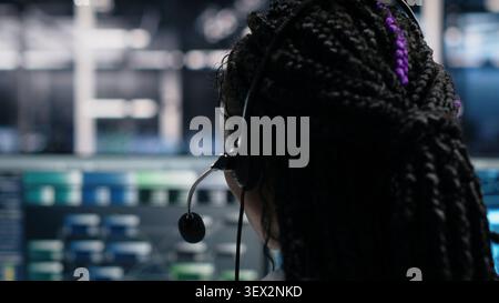 Administrator uses an AI assistant in a server farm to provide technical support and user troubleshooting. Stock Photo