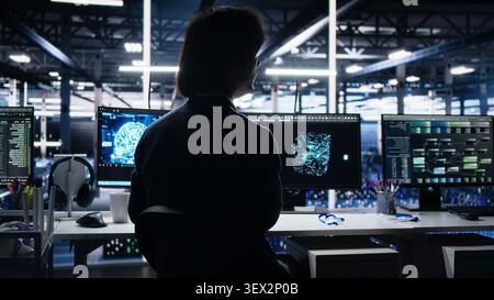 Computing facility software developer working with computer to track neural network AI large language model visualization with in high tech facility working with computer to oversee servers. Stock Photo