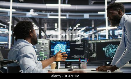 IT technician in wheelchair and high tech server room team supervisor. Stock Photo