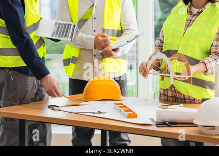 Engineers discussing bridge model and blueprints Stock Photo