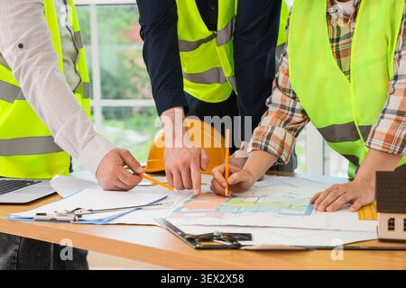 Construction workers collaborating on building plans Stock Photo