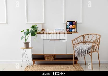 Minimalist living room corner with wicker chair and cabinet Stock Photo