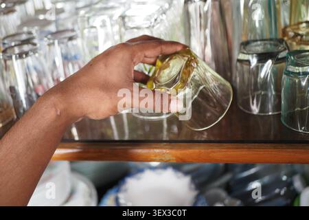 Sorting glass cups on a shelf during a busy day Stock Photo