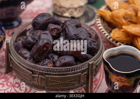 Dried dates. Sweet fruit food. Dessert with coffee cup. Date bowl on table Stock Photo