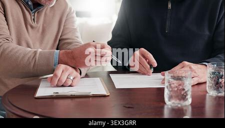 Hands, man and advisor with documents in meeting, finance report and form for loan application. Mature person, consultant and reading in home with Stock Photo