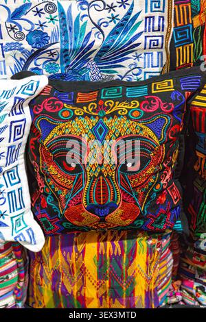 Traditional Guatemalan cushion cover with a colorful embroidered jaguar face. Handmade Mayan home decor fabric. Stock Photo