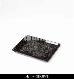 Empty black textured ceramic tray on white background isolated studio close shot Stock Photo