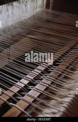 Yarn thread lines on the weaving loom machine. Weaving loom in textile factory. Stock Photo