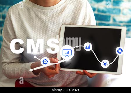 Using a content management system on a tablet for online tasks Stock Photo