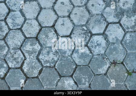 Full frame background of old weathered grey hexagonal concrete paving tiles. Textured geometric stone pavement blocks pattern for architectural backdr Stock Photo