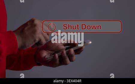 Young man with smartphone hand touching Shut Down button press power OFF Stock Photo