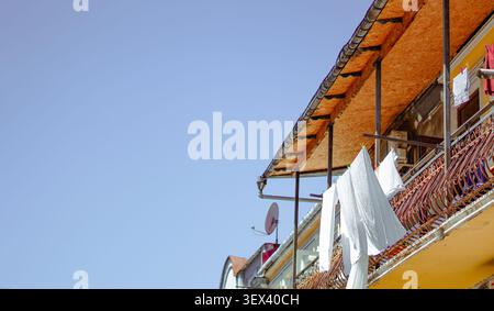 White laundry hangs to dry on a decorative balcony railing. Stock Photo