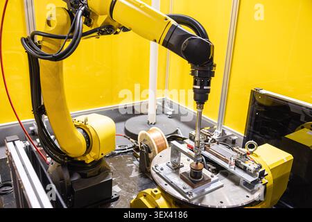 Automation Factory Welding Robot Arm in the Automotive Parts Industry Working Tungsten Inert Gas Copper Wire welding. Stock Photo