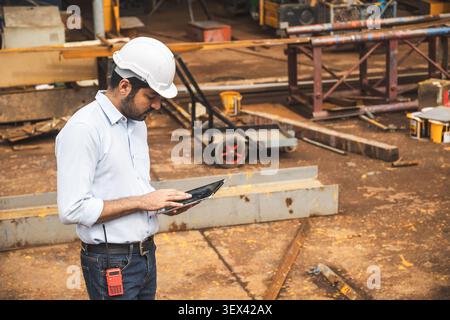 Asian Indian construction Engineer male, Builder lead construction site working control operate crane site. Stock Photo