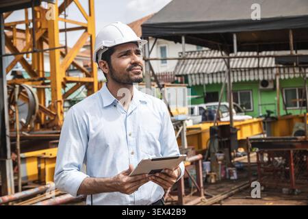 Asian Indian construction Engineer male, Builder lead construction site working control operate crane site. Stock Photo