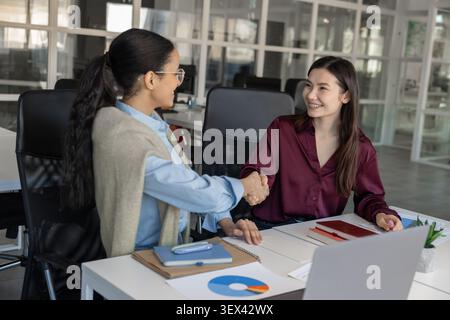 Two young businesswomen shaking hands Stock Photo